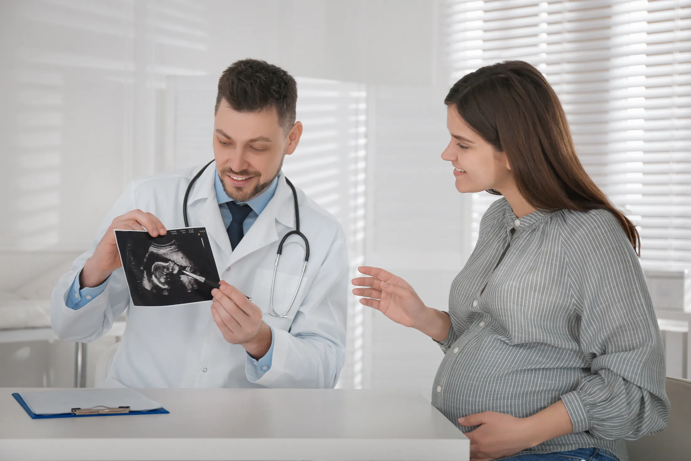gynecologist-showing-ultrasound-picture-pregnant-woman-clinic
